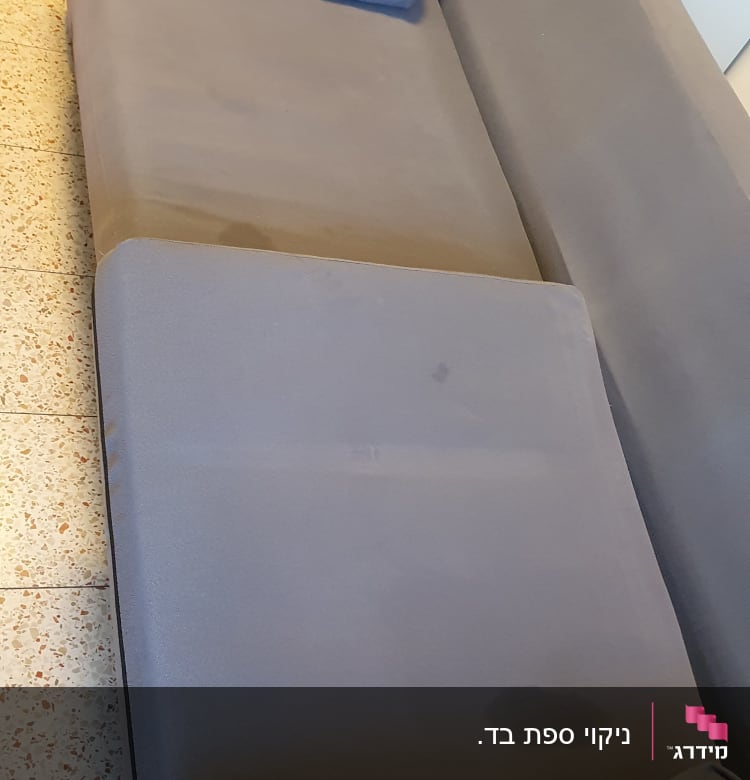 כתמים על ספה כחולה לפני ניקוי